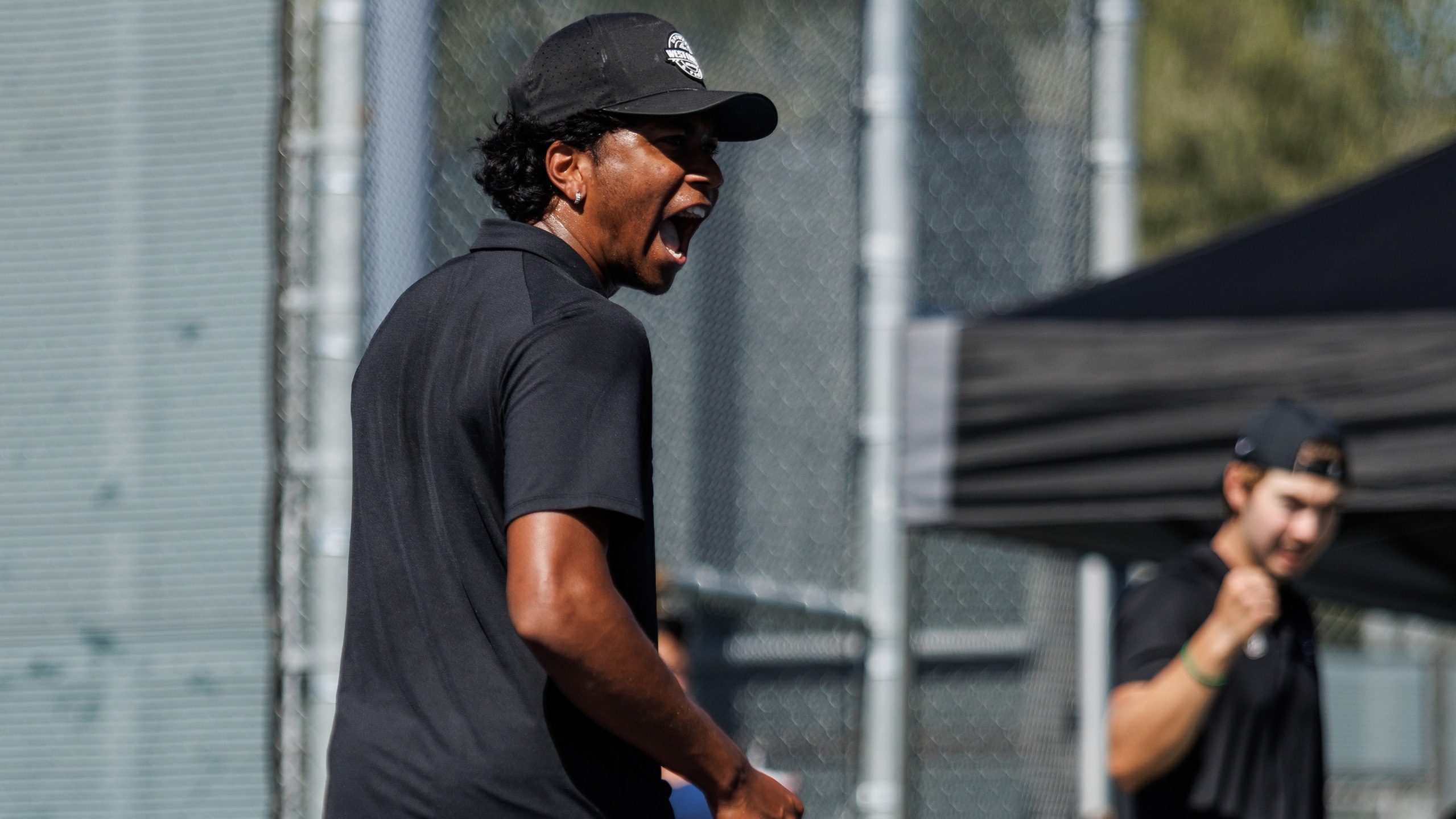 Two male tennis players celebrate a big play.